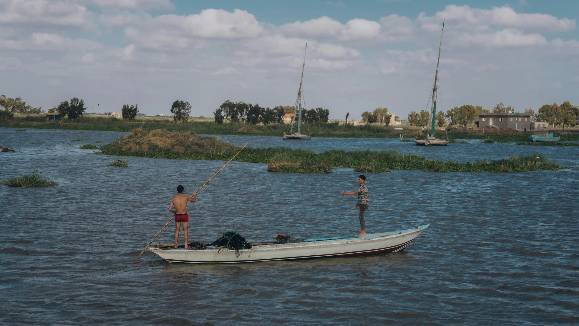 El Gouna, Egypt - Two fishermen engage in traditional fishing on the nile river, capturing authentic egyptian culture.