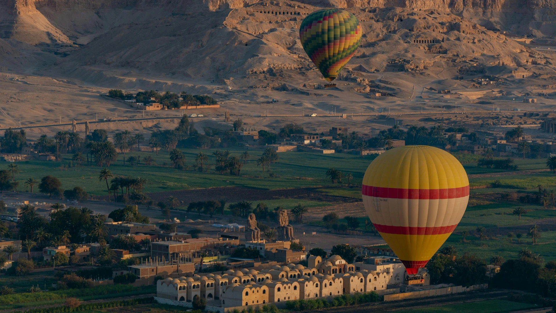 El Gouna, Egypt - Colorful hot air balloons floating over luxor with ancient egyptian landmarks in the background.