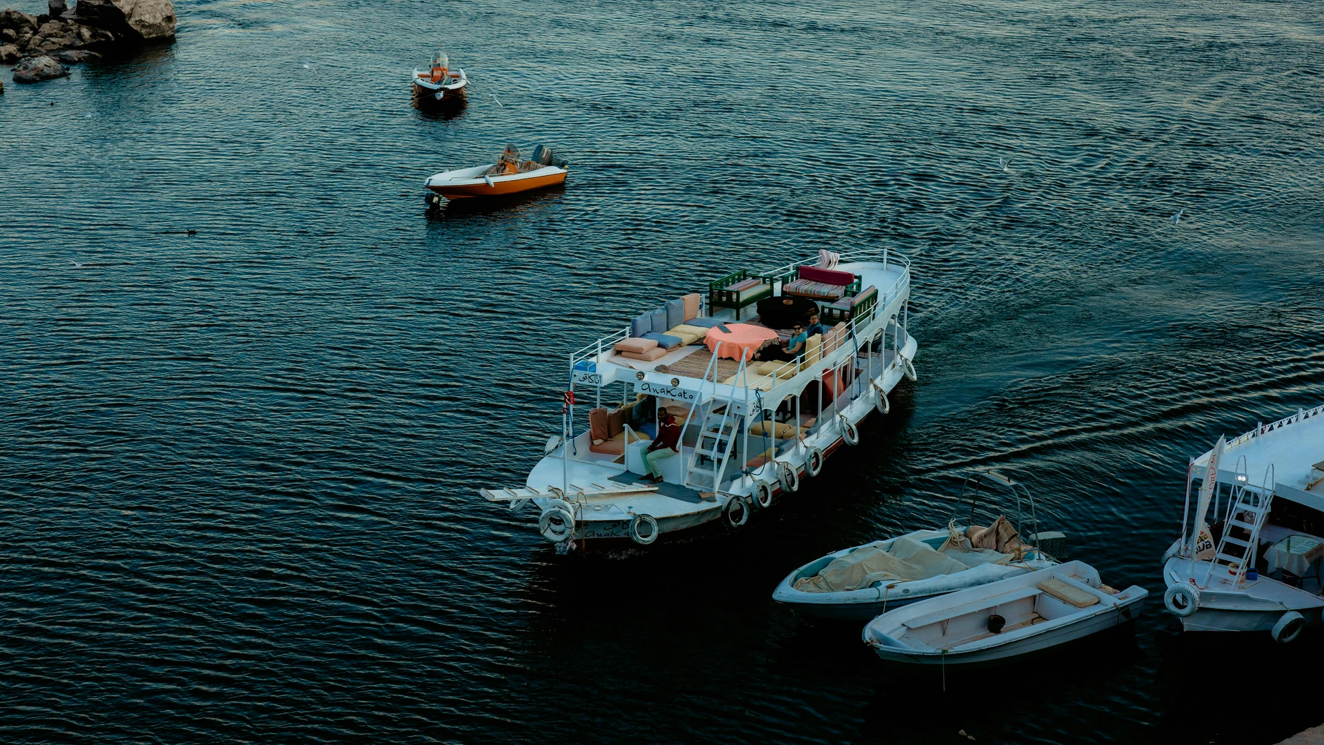 Aswan, Egypt - Scenic view of boats on the nile river in aswan, egypt, showcasing vibrant travel and transportation.
