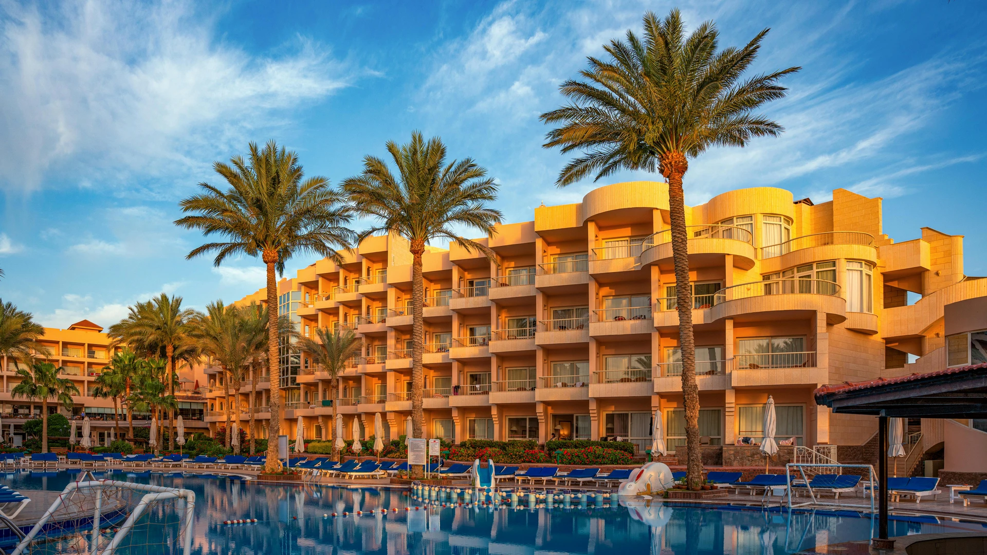 Hurghada, Egypt - Elegant hotel with palm trees and poolside in hurghada, egypt during a sunny day.