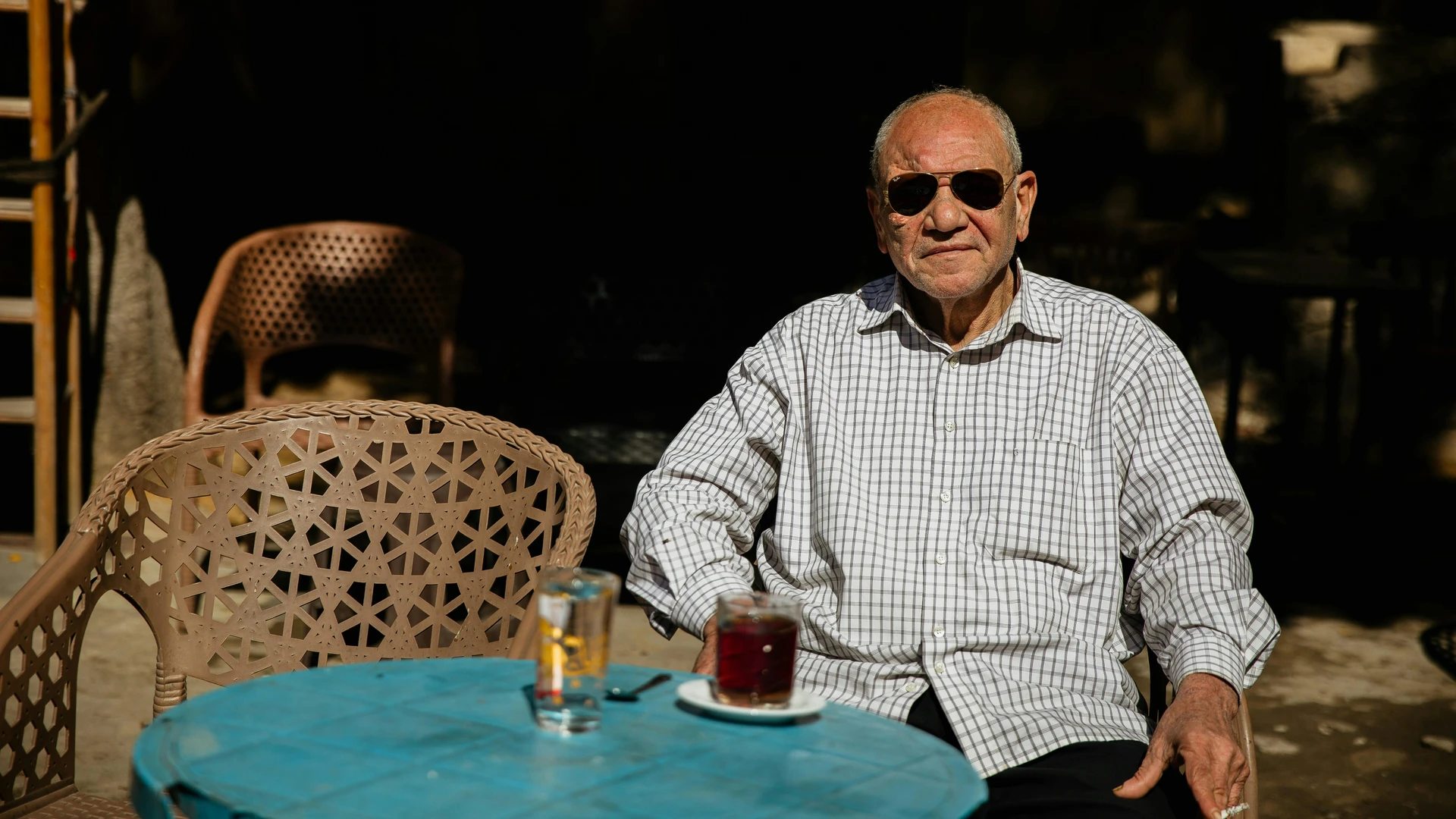 Makadi Bay, Egypt - Elderly man with sunglasses sitting at an outdoor café table in cairo, egypt.